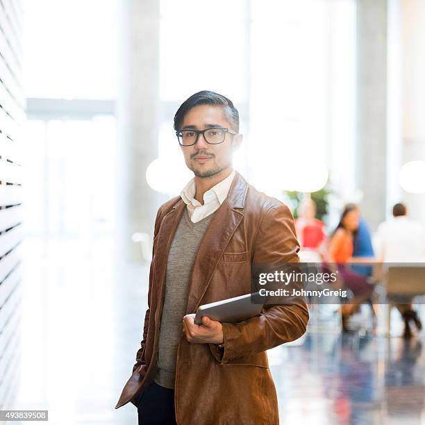 trendy businessman wearing brown leather jacket holding laptop - eurasian stock pictures, royalty-free photos & images