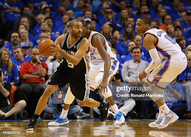 Tony Parker of the San Antonio Spurs handles the ball against Kevin Durant and Russell Westbrook of the Oklahoma City Thunder in the third quarter...