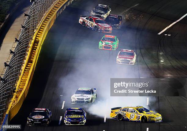 Marcos Ambrose, driver of the Twisted Tea Ford, and Landon Cassill, driver of the HIllman Racing Chevrolet, spin out during the NASCAR Sprint Cup...