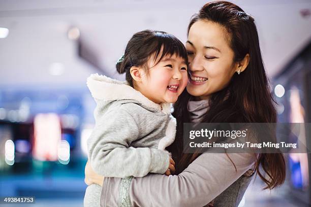 mom holding little girl with love smiling joyfully - chinese young adults shopping imagens e fotografias de stock