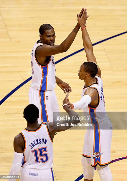 Reggie Jackson, Kevin Durant and Russell Westbrook of the Oklahoma City Thunder high five in the third quarter against the San Antonio Spurs during...