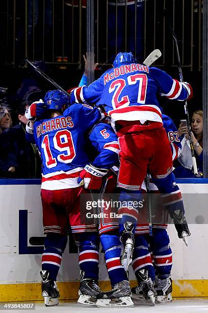 Ryan McDonagh jumps on Martin St. Louis of the New York Rangers after St. Louis scored the game winning shot in overtime against Dustin Tokarski of...