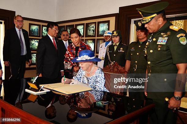 Danish Queen Margrethe II is accompanied by Indonesian officials sign a guest book after her visit to the Kalibata Hero Graveyard in Jakarta,...