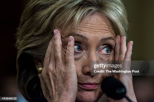 Former Secretary of State Hillary Clinton testifies, and reacts to Chairman Trey Gowdy and Co Chairman Elijah Cummings arguing, during the House...