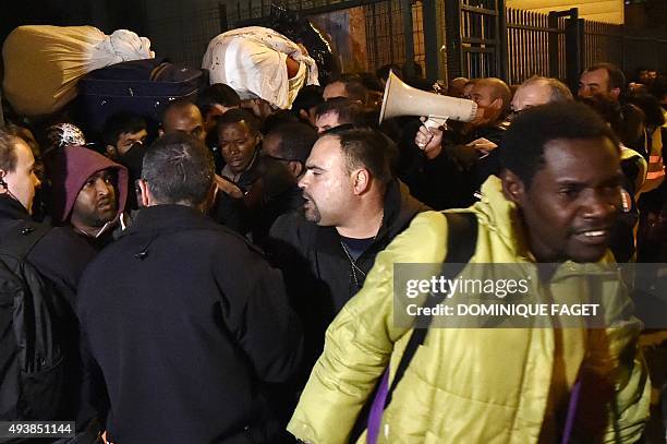 Migrants prepare to leave their makeshift camp after being evicted by the French authorities from a camp set in a disused school, on October 23, 2015...