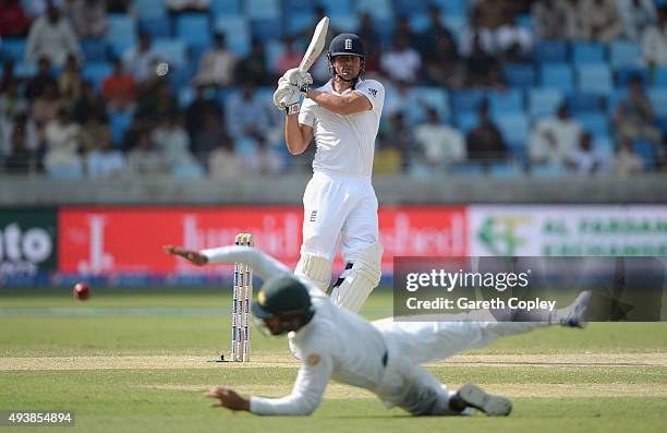 England captain Alastair Cook hits past Shan Masood of Pakistan during day two of the 2nd test match between Pakistan and England at Dubai Cricket...