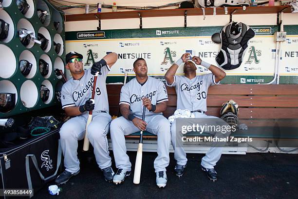 Jose Abreu, Dayan Viciedo and Alejandro De Aza of the Chicago White Sox relax in the dugout prior to the game against the Oakland Athletics at O.co...