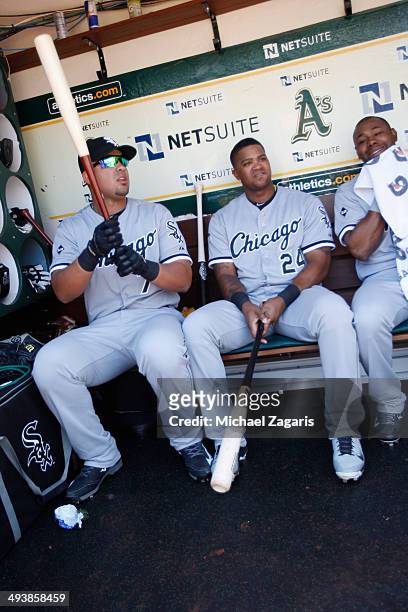 Jose Abreu, Dayan Viciedo and Alejandro De Aza of the Chicago White Sox relax in the dugout prior to the game against the Oakland Athletics at O.co...