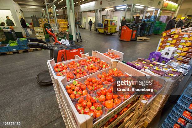 Punnets of strawberries sit in crates in the perishable center of the wholesale food market in Frankfurt, Germany, on Friday, Oct. 23, 2015. Falling...