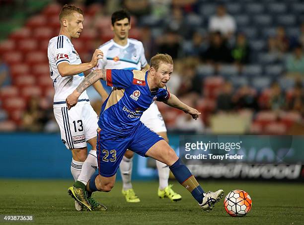 David Carney of the Jets contests the ball with Oliver Bozanic of the Victory during the round three A-League match between the Newcastle Jets and...