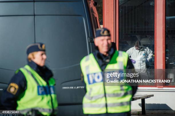 Police officers guard as a forensic staff investigates inside the primary and middle school Kronan in Trollhattan, southwestern Sweden, on October 23...