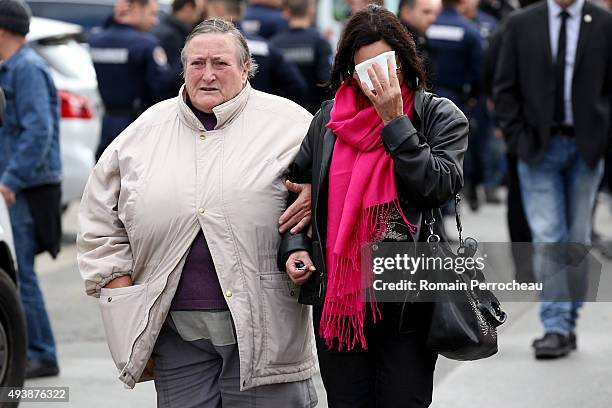 Two women walk near to the scene of a bus crash in which at least 42 people were killed after a collision with a lorry early this morning, on October...