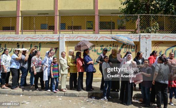 Egyptians wait in queue to cast their ballots outside a polling station during the Egypt's presidential election in the Shubra district of Cairo,...