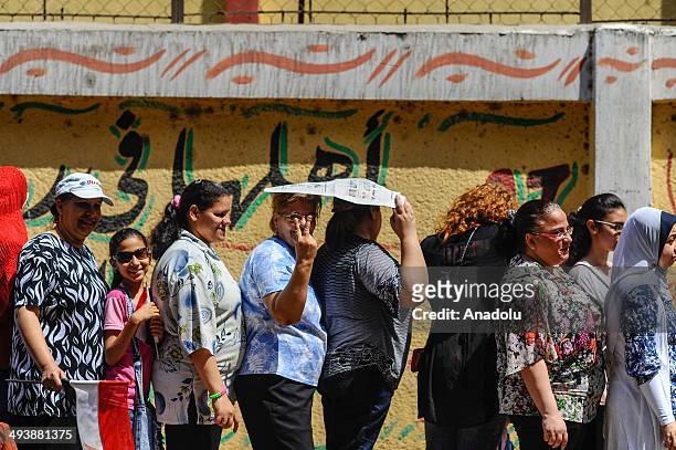 Egyptians wait in queue to cast their ballots outside a polling station during the Egypt's presidential election in the Shubra district of Cairo,...