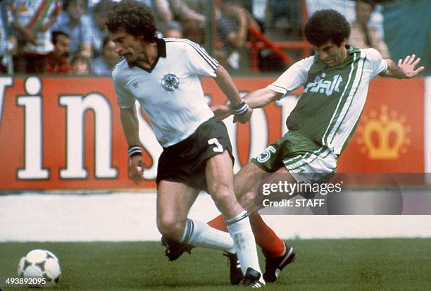 West German defender Paul Breitner tries to control the ball under pressure from Algerian midfiedler Mustapha Dahleb during the World Cup first round...