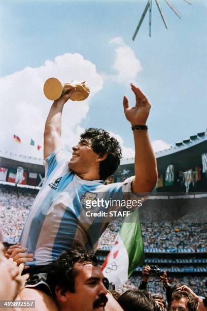 Argentina's soccer star team captain Diego Maradona brandishes the World Soccer Cup won by his team after a 3-2 victory over West Germany on June 29,...