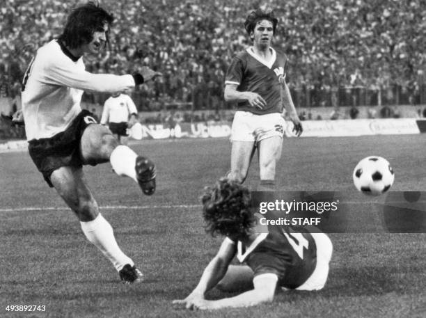 West German forward Gerd Müller kicks the ball past East German defender Konrad Weise as forward Martin Hoffmann looks on during the World Cup first...