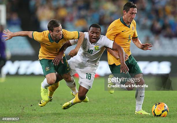 Thuso Phala of South Africa is challenged by Tommy Oar and Mark Milligan of the Socceroos during the International Friendly match between the...
