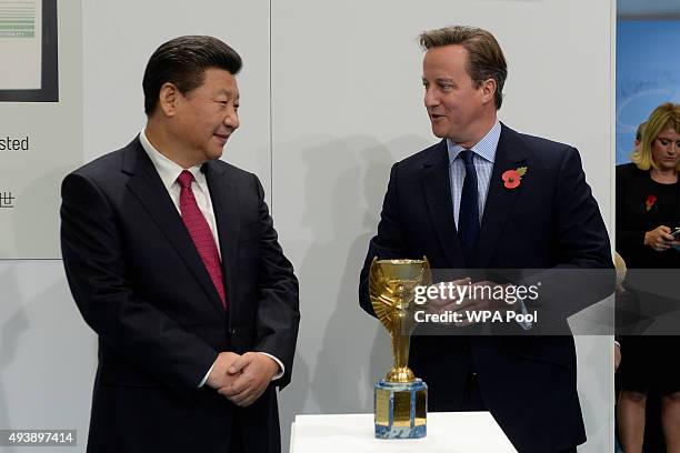 China's President Xi Jinping and Britain's Prime Minister David Cameron view the Jules Rimet trophy during a visit to the City Football Academy on...