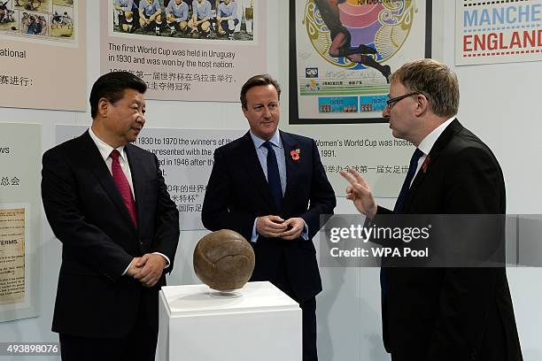 Britain's Prime Minister David Cameron and China's President Xi Jinping view the football used in the first World Cup Final during a visit to the...