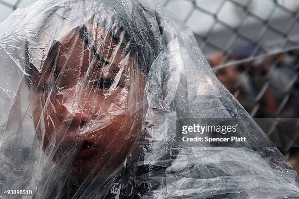 Sick child waits as his father pleads with the authorities to let him into a gate to see a doctor at the migrant processing center at the...