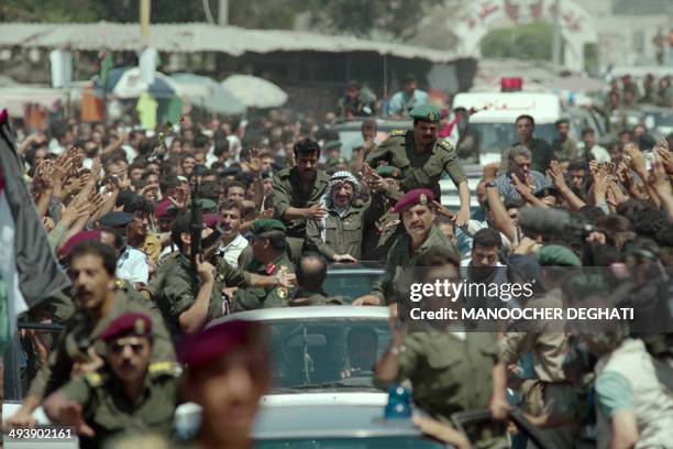 Chairman Yasser Arafat surrounded by bodyguards salutes a cheering crowd of Palestinians during his tour of Gaza City on July 03, 1994. The return of...