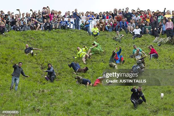 Competitors tumble down Coopers Hill in pursuit of a round Double Gloucester cheese during the annual cheese rolling and wake near the village of...