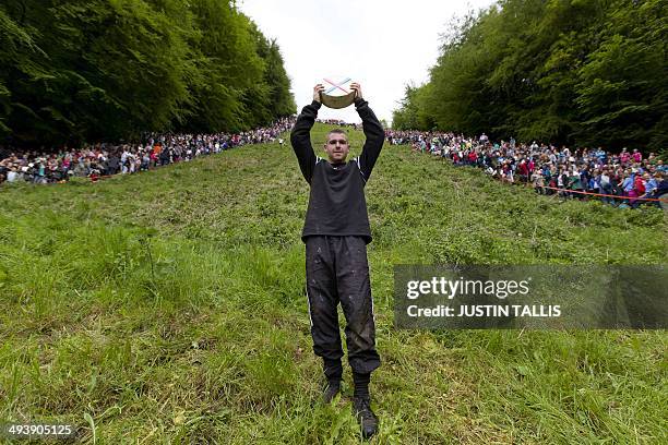 Ryan Fairley from England celebrates after winning a race down Coopers Hill in pursuit of a Double Gloucester cheese during the annual cheese rolling...