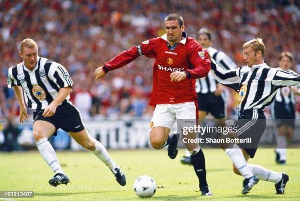 Manchester United player Eric Cantona beats Steve Watson and David Batty during the FA Charity Shield match between Manchester United and Newcastle...