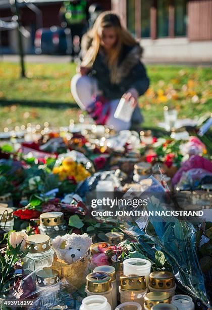 Teenager lights candles outside the primary and middle school Kronan in Trollhattan, southwestern Sweden, on October 23 where a masked man armed with...