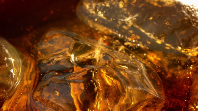 Two videos of cold cola with ice cubes in 4K