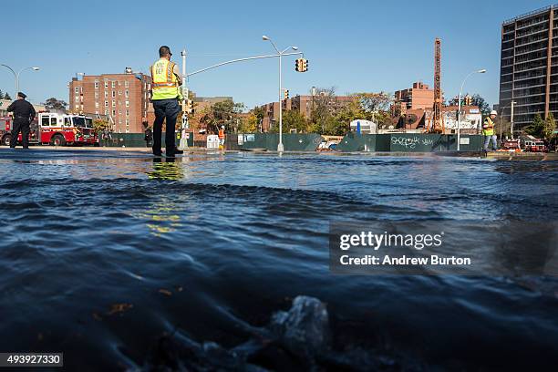 First responder from the New York City Department of Environmental Protection works at the site of a water main break on October 23, 2015 in the...