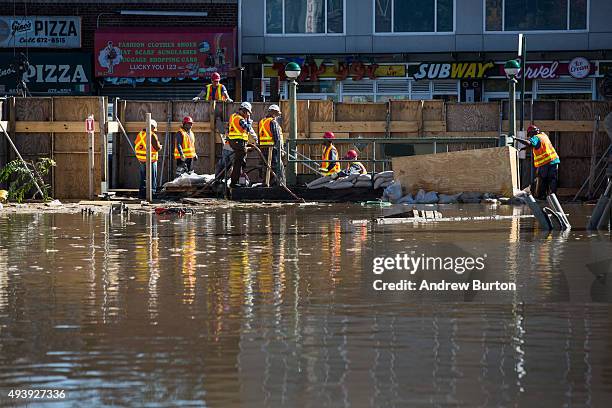 First responders from the Metropolitan Transit Authority work at the site of a water main break on October 23, 2015 in the Elmhurst neighborhood of...