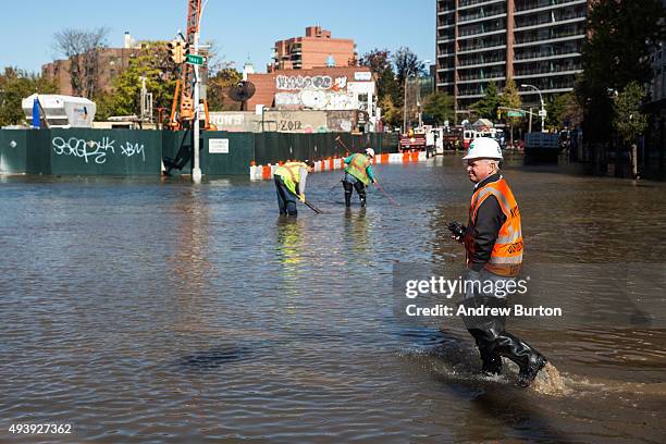 First responders from the New York City Department of Environmental Protection work at the site of a water main break on October 23, 2015 in the...