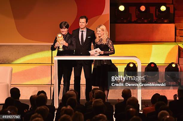 Joachim Loew and Oliver Bierhoff bring the FIFA 2014 World Cup trophy during the Opening Gala of the German Football Museum on October 23, 2015 in...