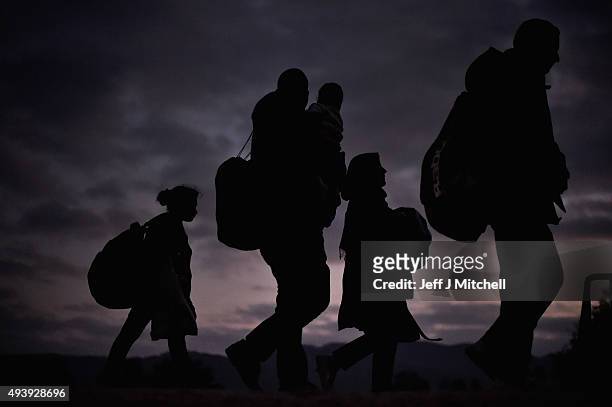 Migrants walk from the village of Rigonce to Brezice refugee camp in tha dark on October 23, 2015 in Rigonce, Slovenia. Thousands of migrants marched...