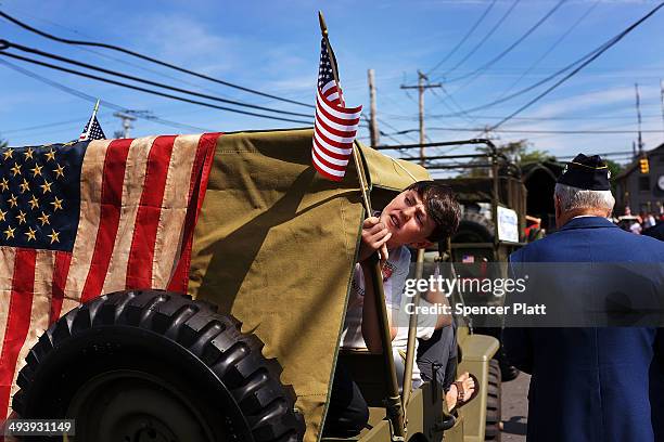 Ben Funk sticks his head out while securing an American Flag to a vintage jeep in the annual Memorial Day Parade on May 26, 2014 in Fairfield,...