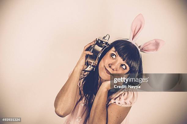 easter bunny weared woman with alarm clock - insomnia funny stock pictures, royalty-free photos & images