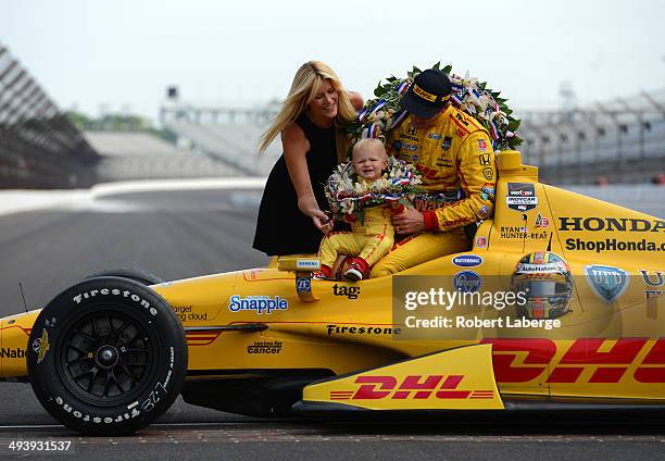 Ryan Hunter-Reay driver of the Andretti Autosport Dallara Honda, his wife Beccy and his son Ryden pose with the Borg Warner Trophy at the yard of...