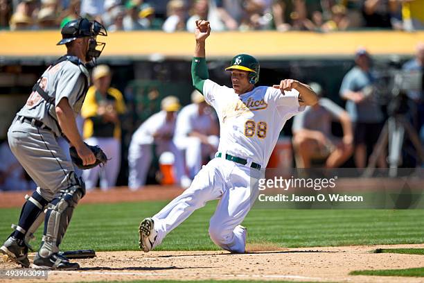 Kyle Blanks of the Oakland Athletics scores a run in front of Bryan Holaday of the Detroit Tigers during the fourth inning at O.co Coliseum on May...