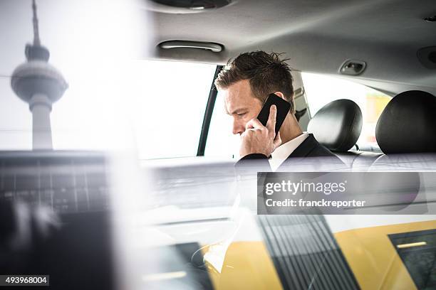 geschäftsmann auf dem telefon im taxi in berlin - berlin international stock-fotos und bilder