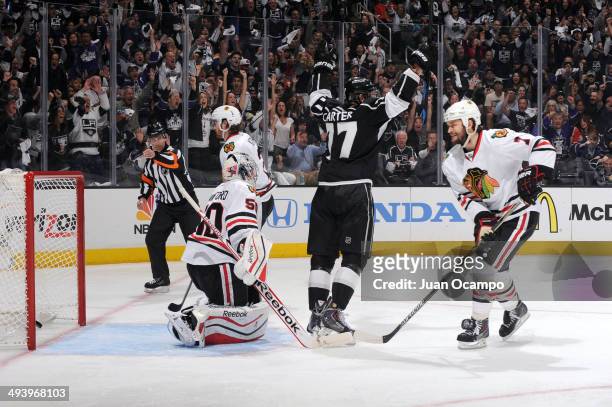 Jeff Carter of the Los Angeles Kings celebrates while Corey Crawford of the Chicago Blackhawks looks on after giving up a goal in Game Four of the...