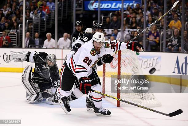 Brandon Saad of the Chicago Blackhawks and Slava Voynov of the Los Angeles Kings go after the puck in the first period in Game Four of the Western...