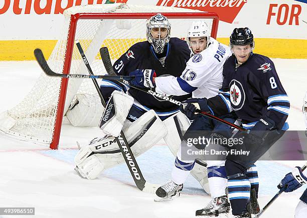 Cedric Paquette of the Tampa Bay Lightning gets in between goaltender Ondrej Pavelec and Jacob Trouba of the Winnipeg Jets as they keep an eye on the...