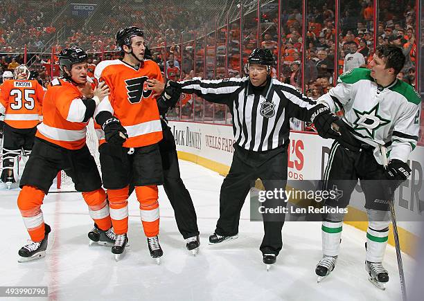 Linesman Jay Sharrers breaks up a scrum between Brandon Manning and Ryan White of the Philadelphia Flyers and Antoine Roussel of the Dallas Stars in...