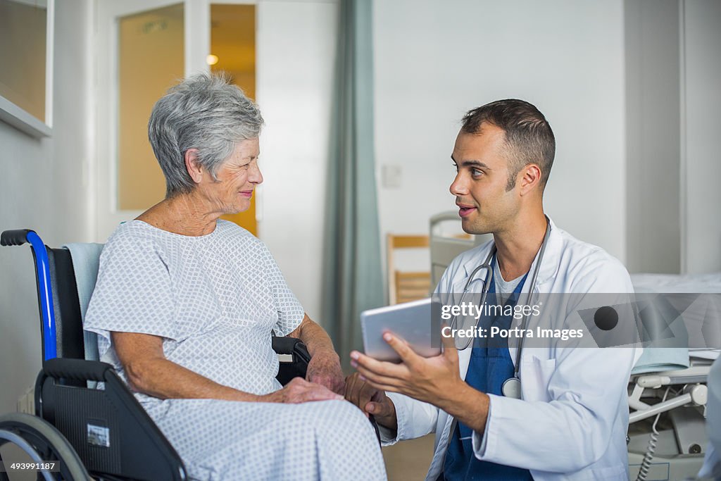 Doctor consulting a senior woman with tablet