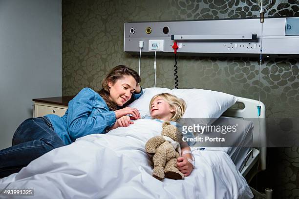child patient in a hospital with her mom. - child hospital bed stockfoto's en -beelden