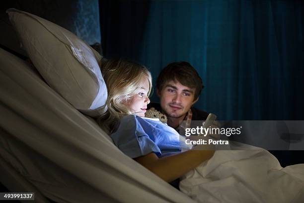 father and daughter watching a digital tablet - child hospital stock-fotos und bilder