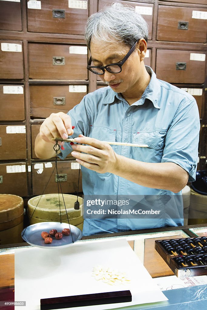 Chinese apothecarian weighing dried cherries