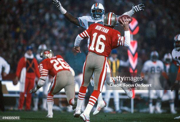 Joe Montana of the San Francisco 49ers drops back to pass under pressure form the Miami Dolphins defense during Super Bowl XIX on January 20, 1985 at...